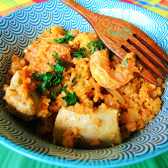 Assiette de crevettes et de poulet accompagné de riz épicé et d'une fourchette en bois